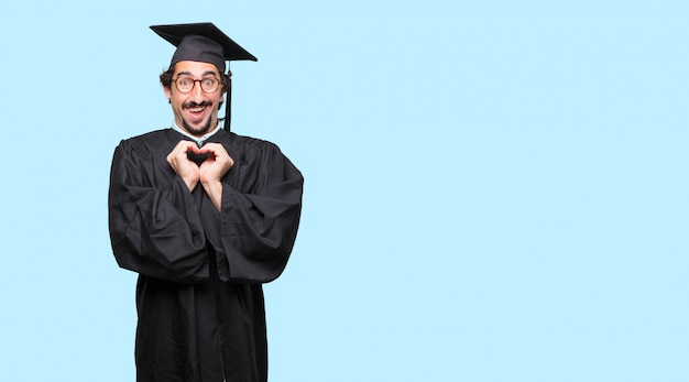 Young graduated man standing sideways, smiling, looking happy and in love