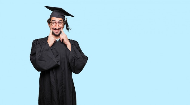 young graduated man with a satisfied and happy look on her face, smiling sincerely