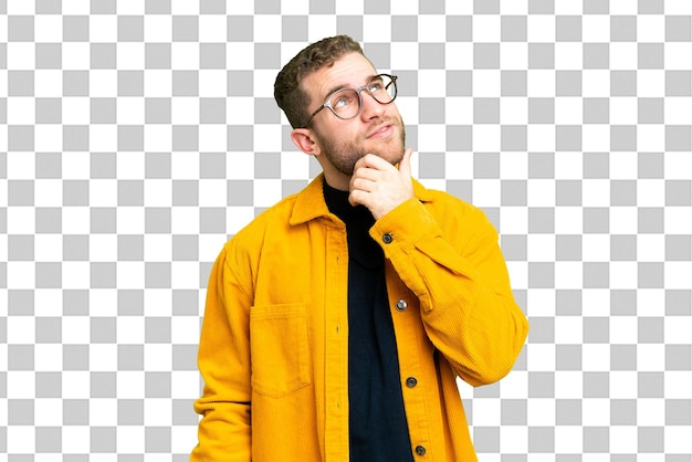 Young handsome blonde man over isolated chroma key background and looking up