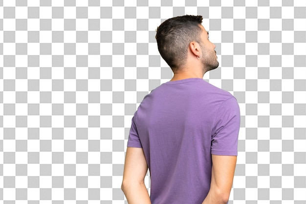 PSD young handsome caucasian man over isolated background in back position and looking back