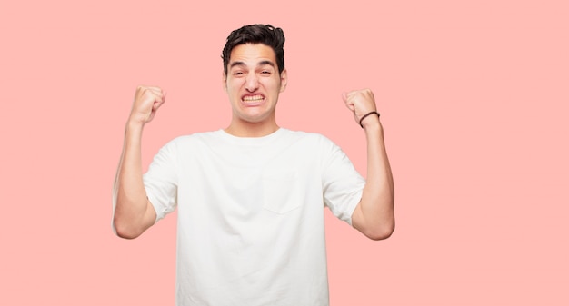 young handsome man Gesturing victory, with a happy, proud and satisfied look on face