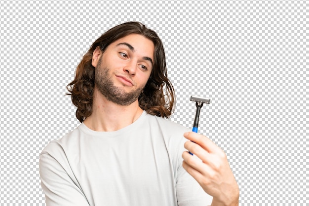 Young handsome man shaving his beard over isolated background with sad expression