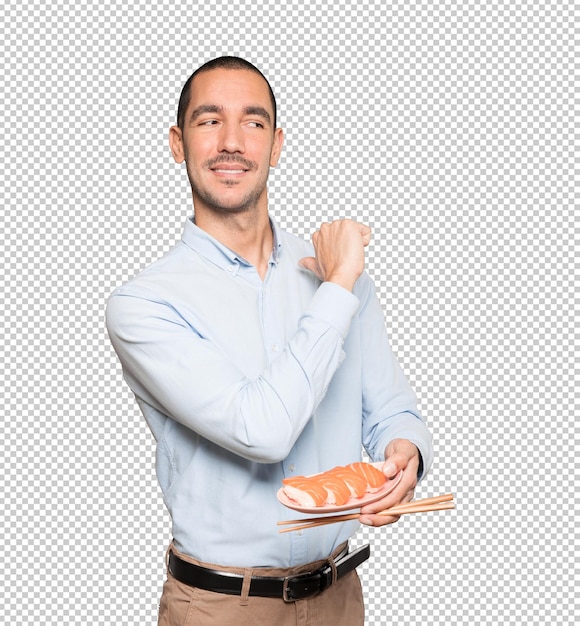 Young man using chopsticks to eat sushi