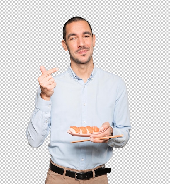 Young man using chopsticks to eat sushi