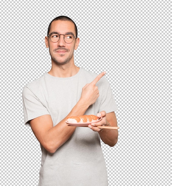 PSD young man using chopsticks to eat sushi