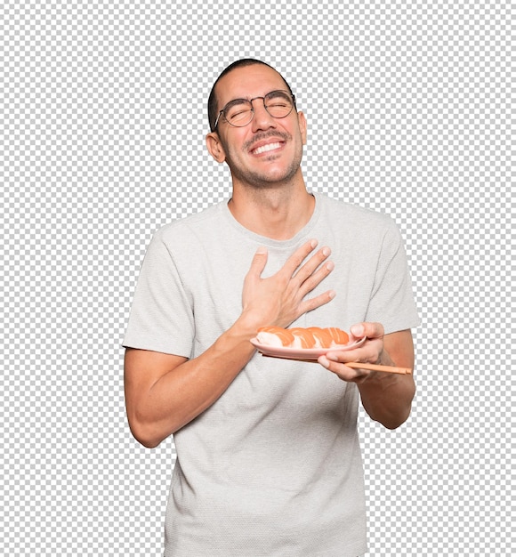 PSD young man using chopsticks to eat sushi