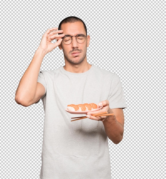 PSD young man using chopsticks to eat sushi