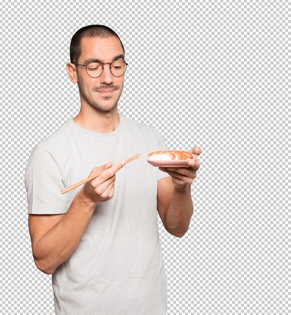 PSD young man using chopsticks to eat sushi