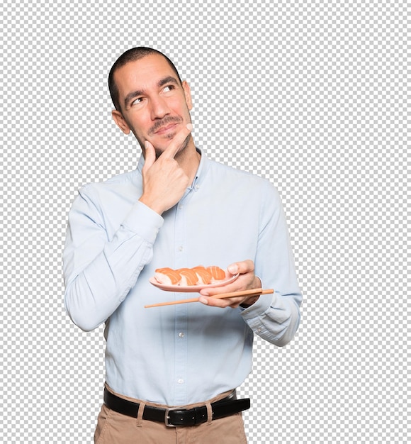 PSD young man using chopsticks to eat sushi