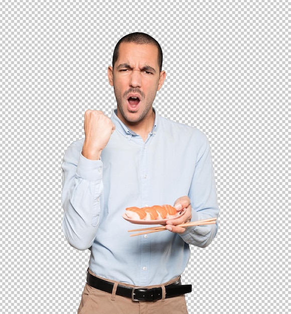Young man using chopsticks to eat sushi