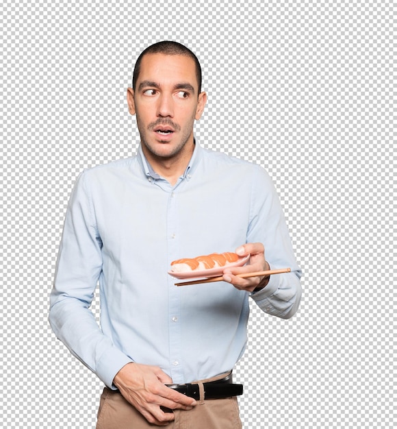 PSD young man using chopsticks to eat sushi