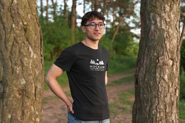 Young man wearing a mock-up t-shirt in the forest