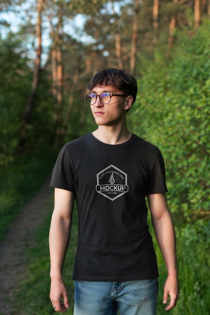 PSD giovane che indossa una t-shirt mock-up nella natura