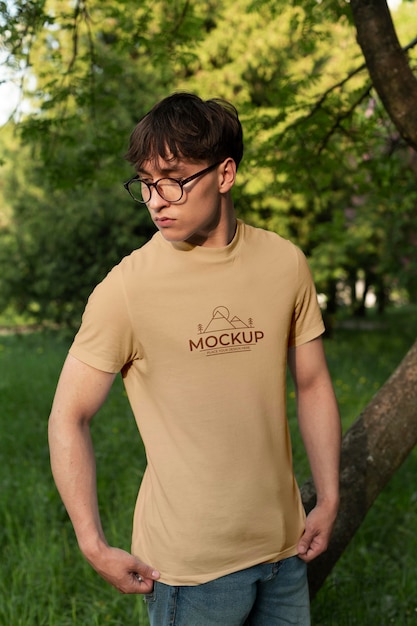 PSD young man wearing a mock-up t-shirt outdoors