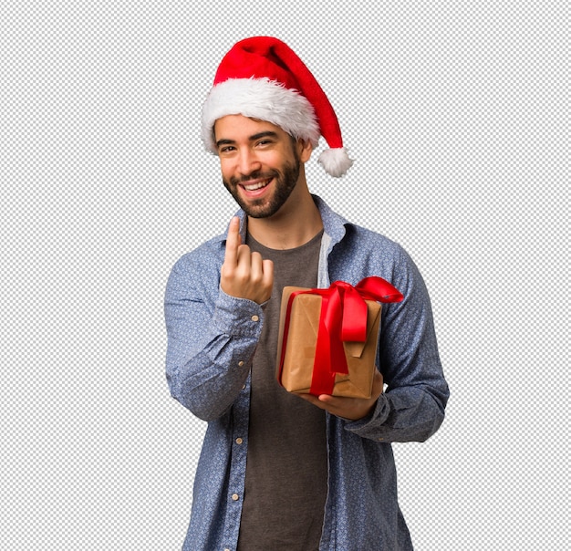 Young man wearing santa hat inviting to come