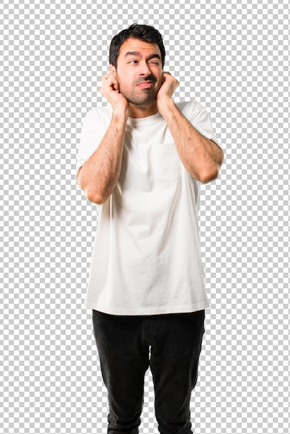 Giovane uomo con la camicia bianca che copre entrambe le orecchie con le mani. espressione frustrata