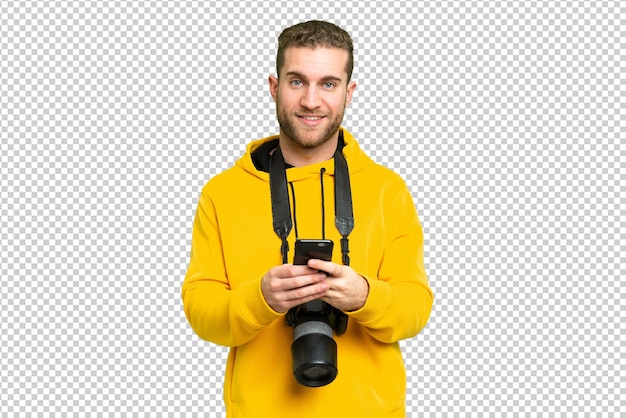 young photographer man over isolated chroma key background sending a message with the mobile