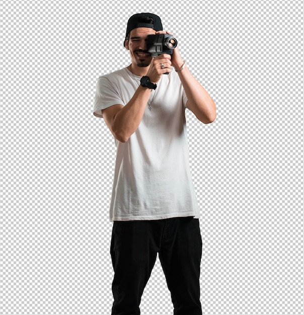 Young rapper man excited and entertained, looking through a film camera, looking for an interesting shot, recording a movie, executive producer