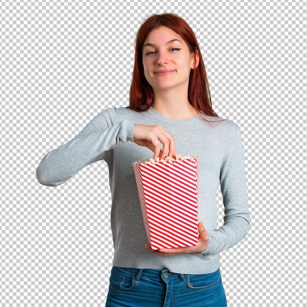 PSD young redhead girl eating popcorns in a big bowl