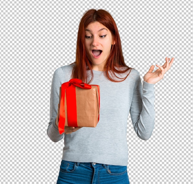 PSD young redhead girl surprised because has been given a gift