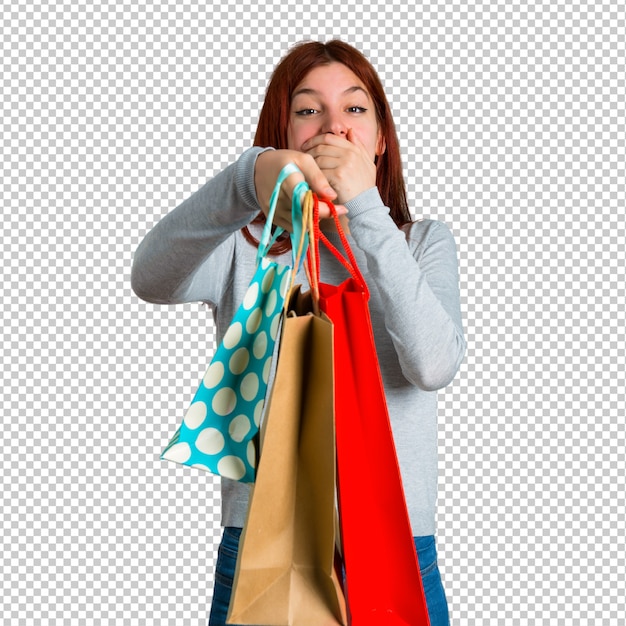 young redhead girl surprised and holding a lot of shopping bags