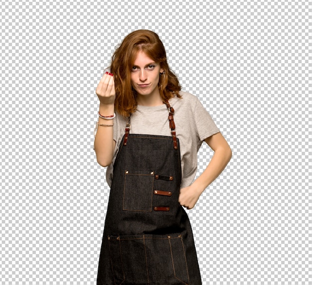 Young redhead woman with apron making italian gesture
