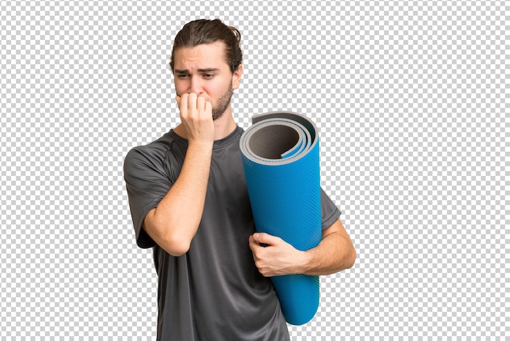 PSD young sport man going to yoga classes while holding a mat over isolated background having doubts