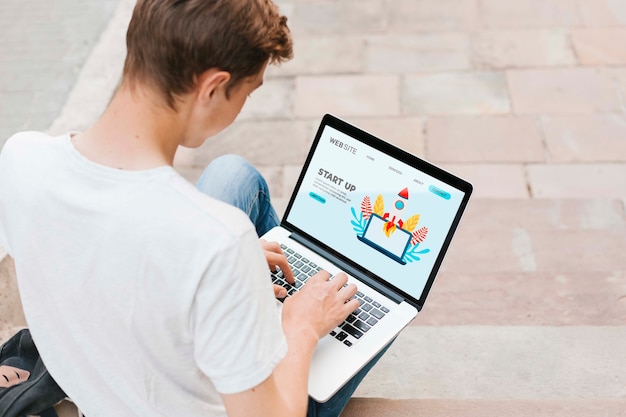 Young student working on laptop outdoors