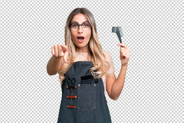 young uruguayan hairdresser woman over isolated background surprised and pointing front