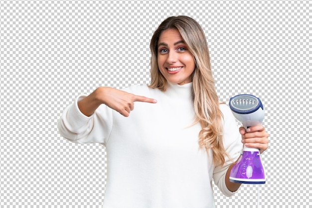 PSD young uruguayan woman holding an iron over isolated background with surprise facial expression