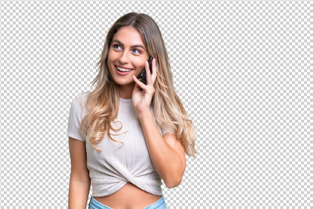 young uruguayan woman over isolated background keeping a conversation with the mobile phone