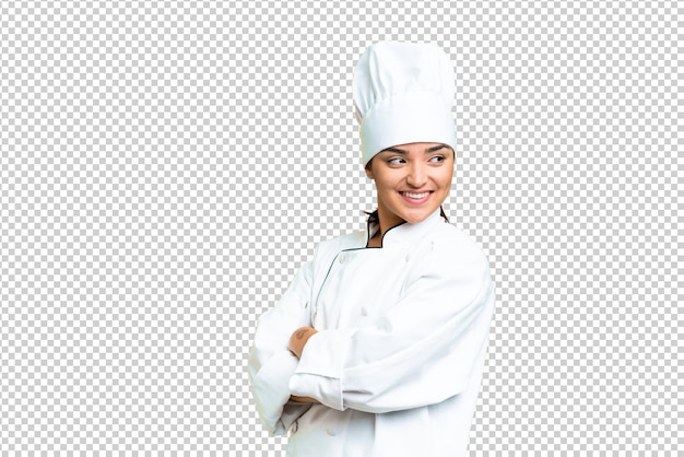 Young woman Chef over isolated chroma key background with arms crossed and happy