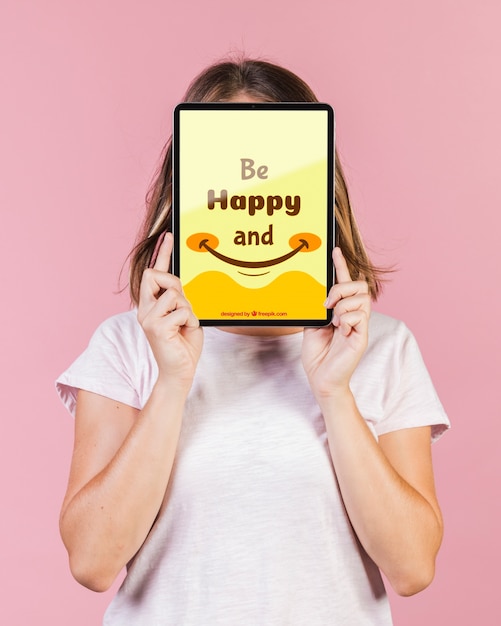 Young woman covering the face with a tablet mock-up