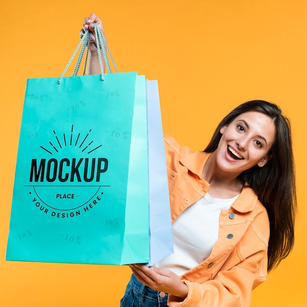 Young woman holding shopping bags mock-up