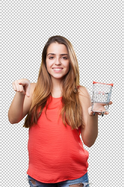 Young woman holding a shopping cart pointing to front