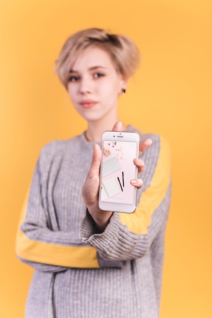 PSD young woman holding smartphone mockup