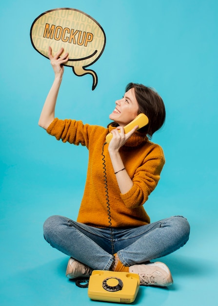 Young woman with chat bubble and old phone