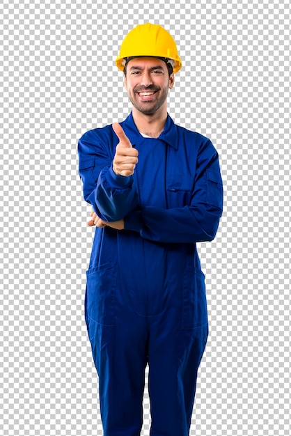 Young workman with helmet giving a thumbs up gesture and smiling because something good has happened