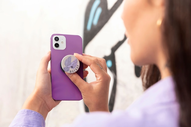 PSD zijaanzichtvrouw die popsocket op haar telefoon gebruikt