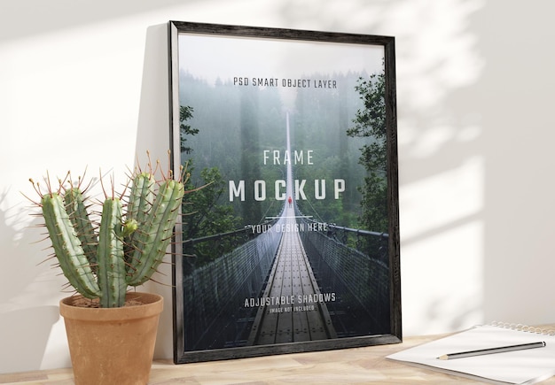 Zwart frame leunend op houten bureau Mockup