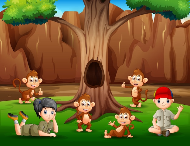 Мальчик и девочка отдыхают под деревом с обезьянами