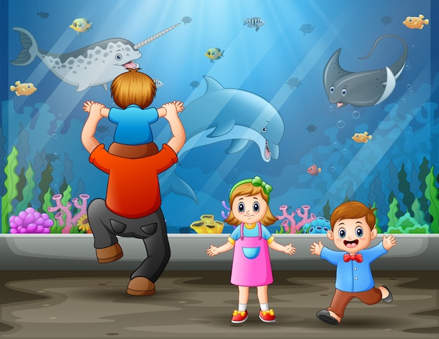 Отец с детьми смотрит на плавание рыб