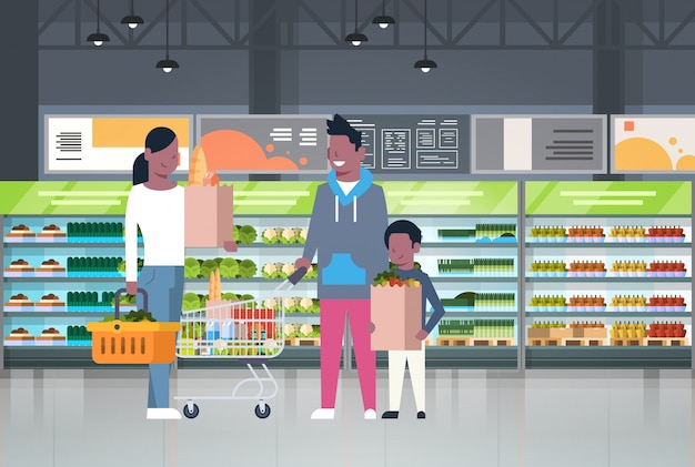 Семья афроамериканцев делает покупки в супермаркете и покупает продукты