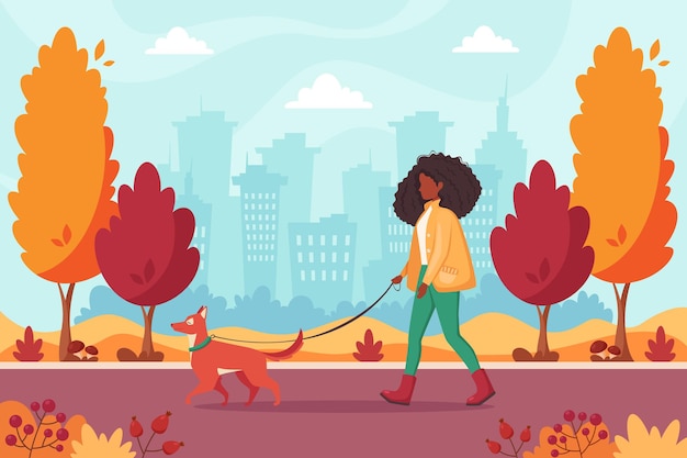 African american woman walking with dog in autumn park