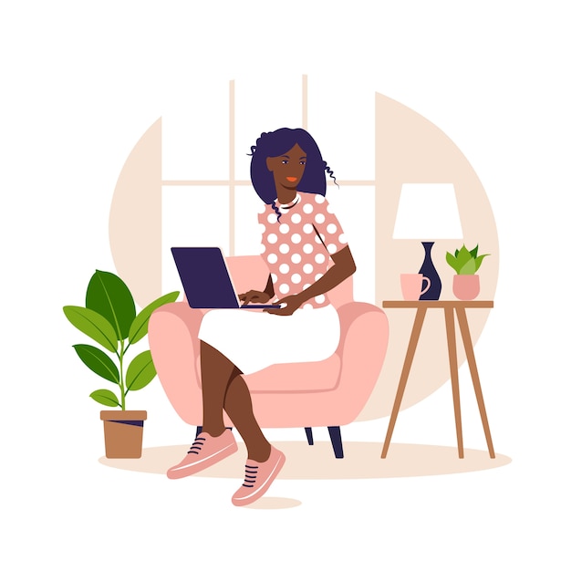 African woman sitting on the armchair with laptop. working on a computer.