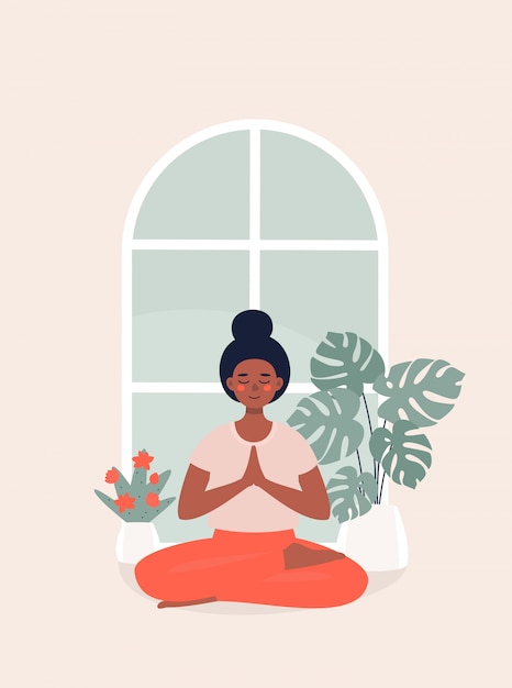 Afro woman sitting in lotus position at home by potted plant