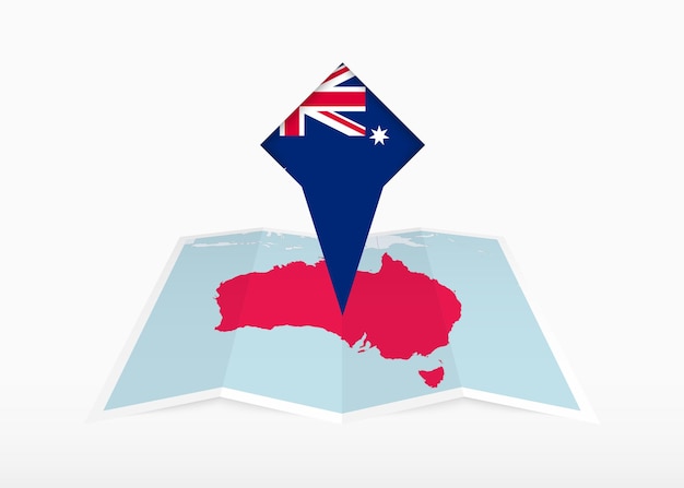 オーストラリアは折りたたまれた紙の地図に描かれ,オーストラリアの旗が付いている位置標識が付いています
