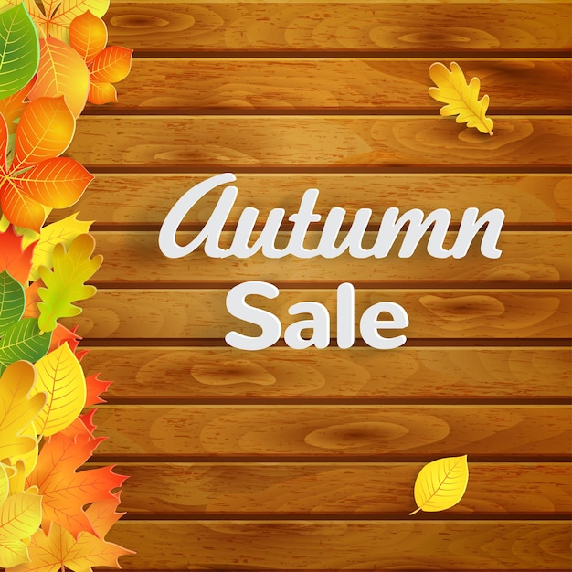 Autumn background with yellow green orange leaves on horizontal planks and text autumn sale