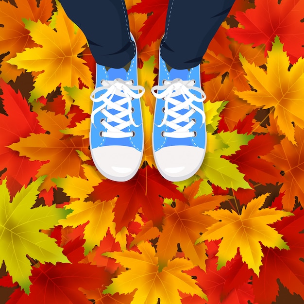 Осенние листья фон шаблон с кленовыми листьями ноги вид сверху в кроссовках на красочные падающие листья.