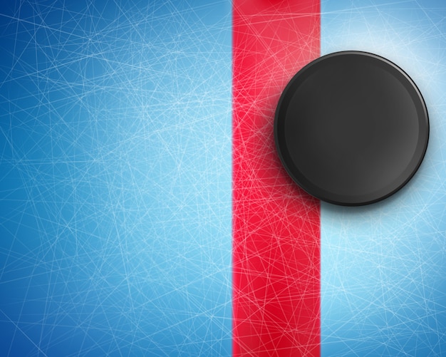 Black rubber puck on the blue ice